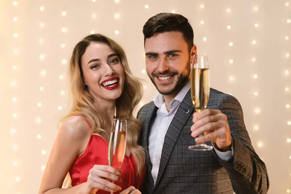 Um brinde. Casal romântico posando com taças de champanhe, saudação com feriados — Fotografia de Stock