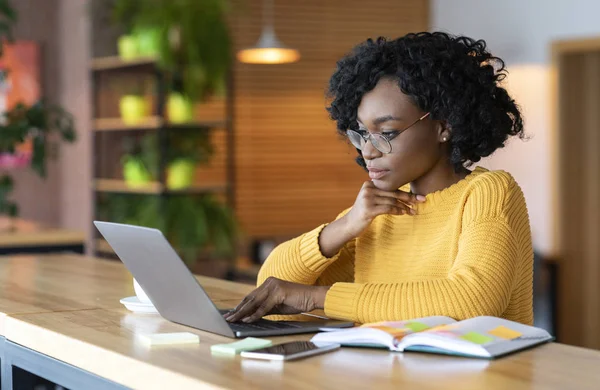 Schwarzes Mädchen arbeitet im Café, surft auf Laptop — Stockfoto
