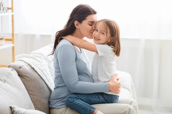 Gravid kvinna kysser sin söta lilla dotter — Stockfoto