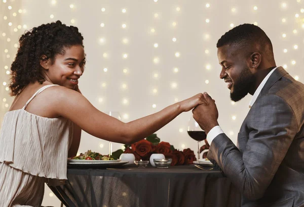 Tampan pria kulit hitam mencium tangan pacarnya saat makan malam — Stok Foto