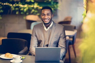 Barda kameraya bakan yakışıklı afro adamın portresi.