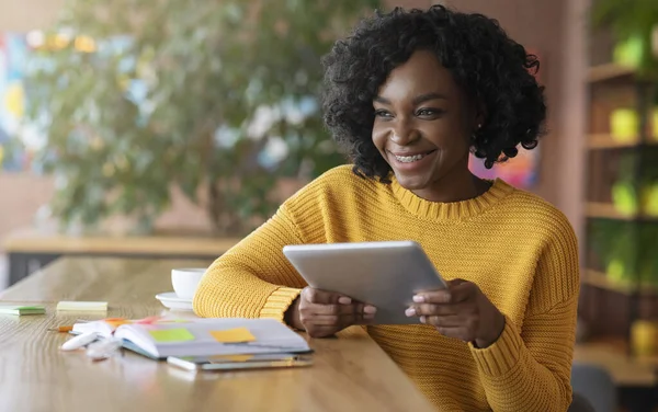 Sorridente ragazza africana utilizzando tablet digitale in caffè — Foto Stock