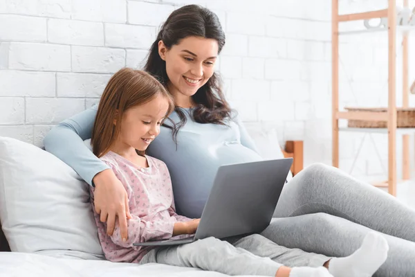 Terhes anya tanítás lánya forró használni laptop — Stock Fotó