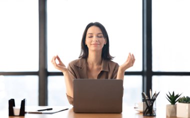 Ofiste meditasyon yapan bir kız stresle boğuşuyor.