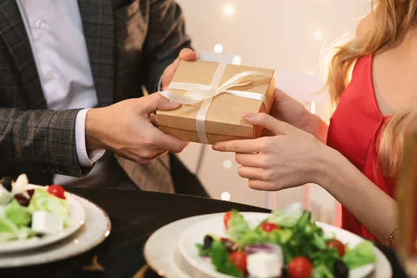 Man giving gift box to girlfriend on romantic dinner in restaurant — 스톡 사진