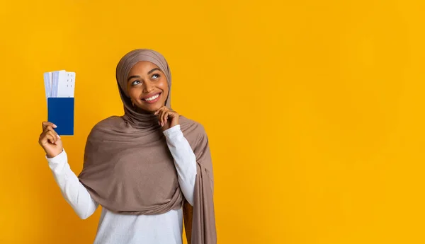 Sonhador preto muçulmano menina no hijab segurando passaporte com bilhetes — Fotografia de Stock