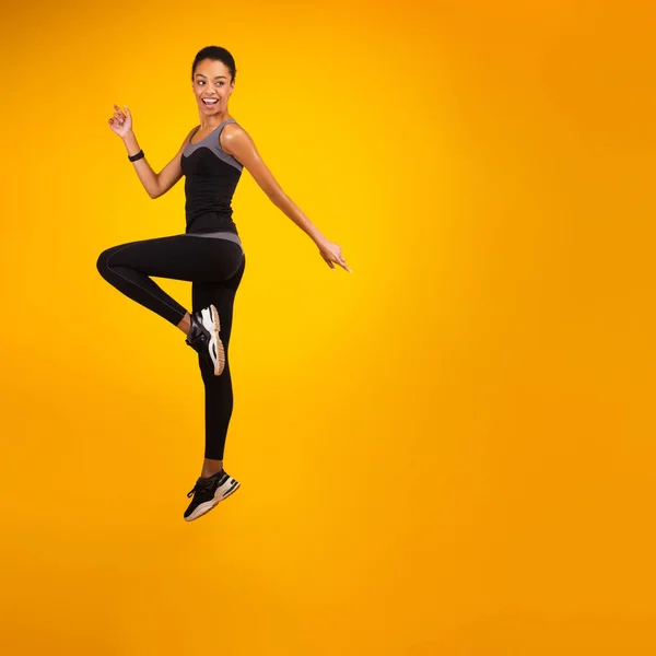 Afro-americana dama saltar sobre amarillo estudio fondo —  Fotos de Stock