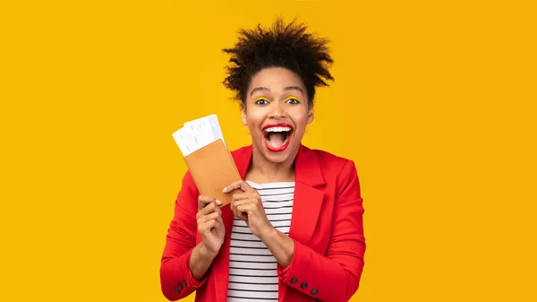 Захоплена чорна дівчина тримає квитки і паспорт — стокове фото