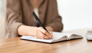 Yöneticinin kalemle not aldığı kırpılmış resim