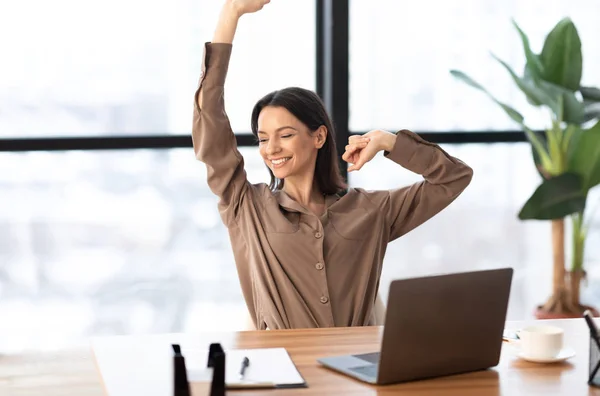 Feliz chica europea estirando el cuerpo en el lugar de trabajo —  Fotos de Stock