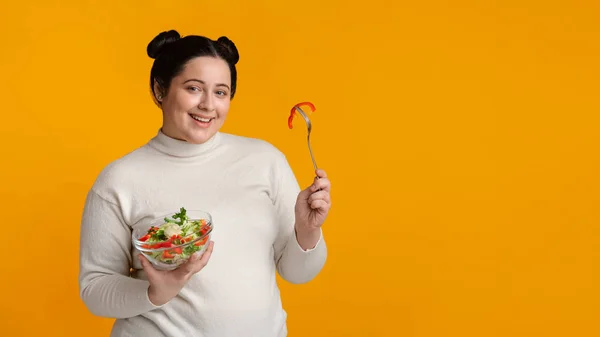 太りすぎの女の子は新鮮な野菜サラダとボウルを保持し、健康的な食品を食べる — ストック写真