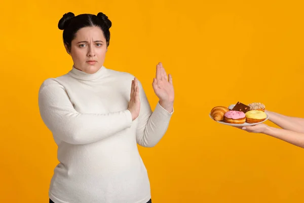 Fettes Mädchen weigert sich, leckere Süßigkeiten auf dem Teller zu konsumieren — Stockfoto