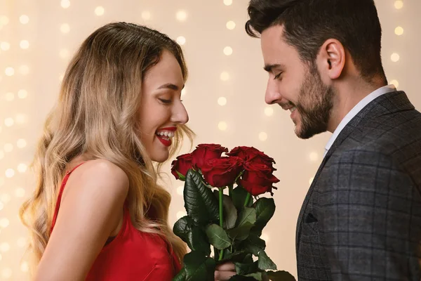 Galante homem apresentando rosas bouquet para seu feliz namorada — Fotografia de Stock