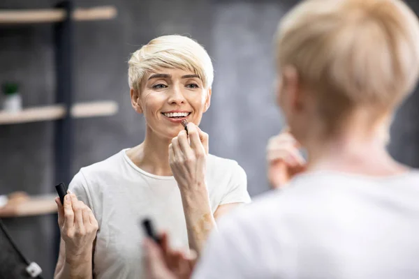 Wanita Paruh Tengah Menerapkan Lipstik Pada Bibir Berdiri di Kamar Mandi — Stok Foto