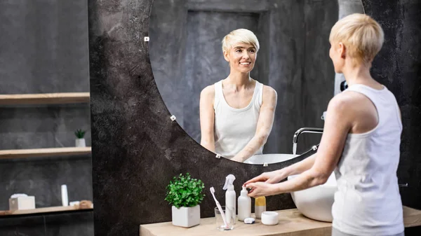 中年妇女洗手站在浴室，全景，复印空间 — 图库照片