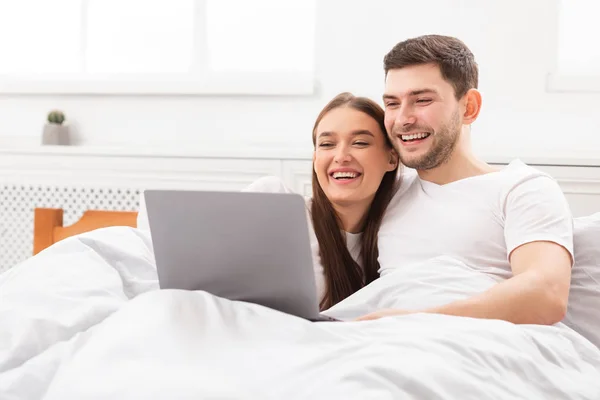 Couple Regarder un film sur ordinateur portable couché dans le lit à la maison — Photo