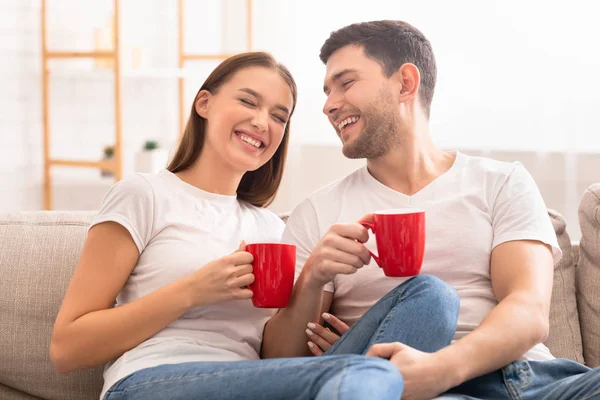 Vesel Cuplu Râzând Având Cafea Așezat Pe Canapea Interioară — Fotografie, imagine de stoc