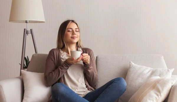 Positief jong meisje genieten van de geur van verse hete koffie — Stockfoto