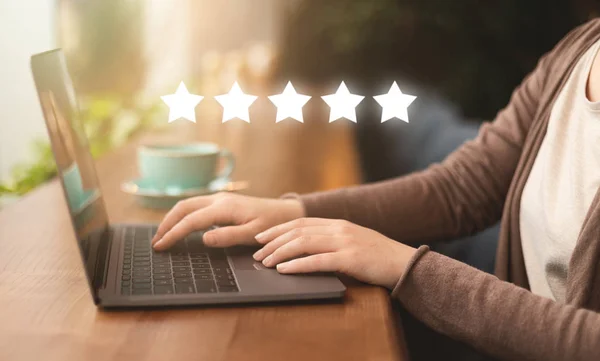 Girl in internet cafe giving high quality rating on laptop — Stock Photo, Image