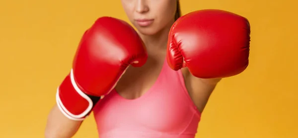 Donna in forma irriconoscibile in guanti da boxe rossi in posa su sfondo giallo — Foto Stock