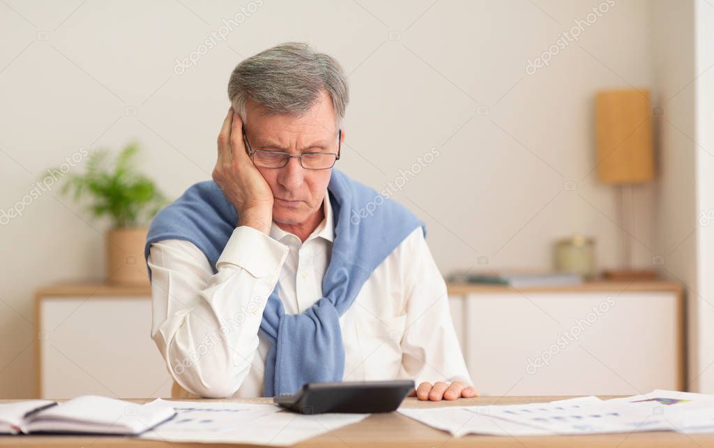 Elderly Man Using Calculator Working Sitting At Workplace In Office