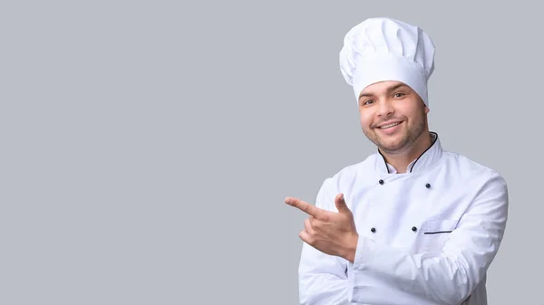 Cook Man Pointing Finger Aside Over Gray Studio Background, Panorama — Stock Photo, Image