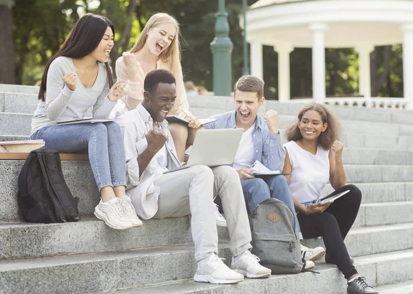 Grupa studentów świętujących sukces, sprawdzanie wyników egzaminu online — Zdjęcie stockowe