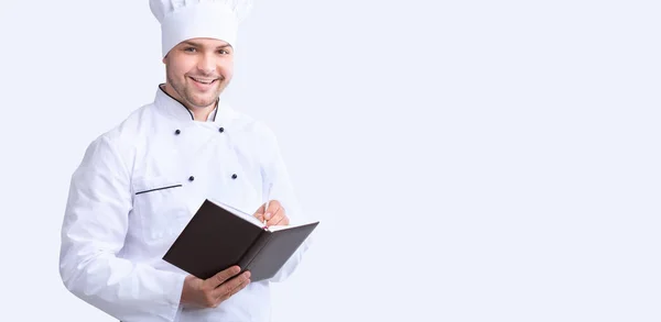 Chef Guy Writing Recipes Standing Over White Background, Panorama — Stock Photo, Image