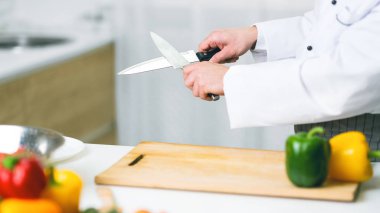 Unrecognizable Cook Guy Sharpening Knives In Restaurant Kitchen, Panorama, Cropped