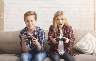 Cute Brother And Sister Playing Video Game Sitting On Couch clipart