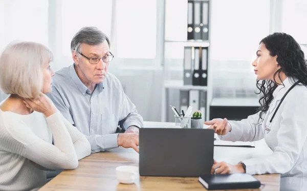 Mexican doctor explaining diagnosis to elderly couple — Stock Photo, Image