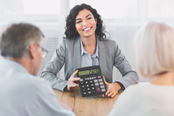 Consultor financeiro mexicano mostrando calculadora para amadurecer casal — Fotografia de Stock