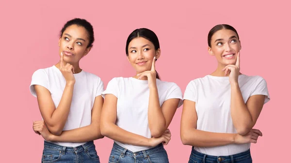 Drie Millennial meisjes dromen aanraken kin over roze achtergrond, Panorama — Stockfoto