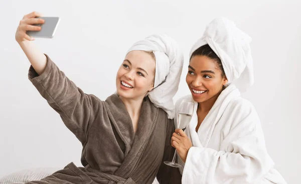 Multi-etnische vriendinnen nemen selfie in badjassen, met spa dag — Stockfoto