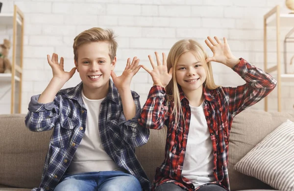 Junge und Mädchen haben Spaß beim Grimassenlächeln auf dem Sofa — Stockfoto