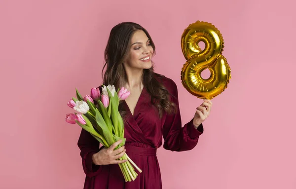 Happy Woman tenant bouquet de tulipes et numéro huit en forme de ballon — Photo