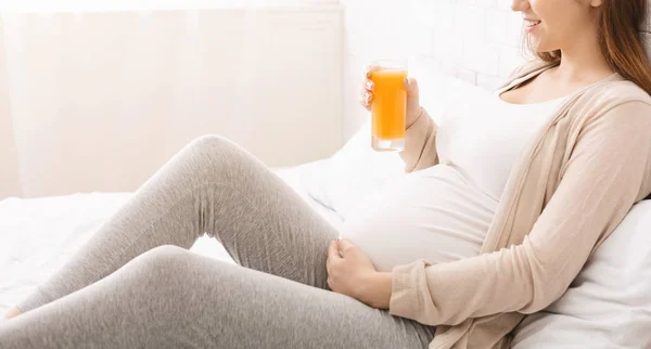 Hamile kadın yatakta portakal suyu içiyor, panorama. — Stok fotoğraf
