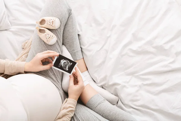 Mujer embarazada disfrutando de su foto de ultrasonido bebé —  Fotos de Stock