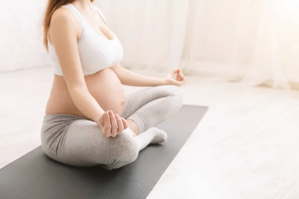 Mulher grávida praticando exercícios de relaxamento em casa — Fotografia de Stock