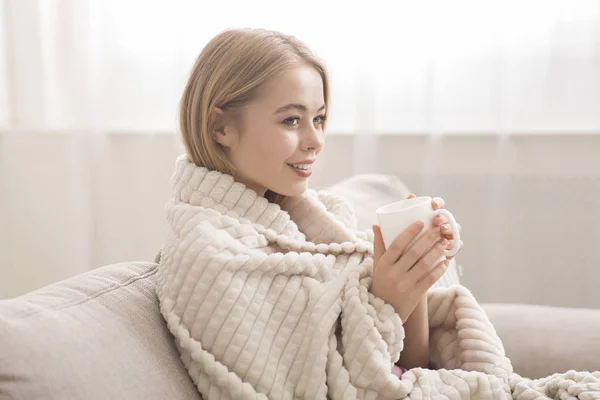 Jovem envolto em cobertor bebendo chá quente — Fotografia de Stock