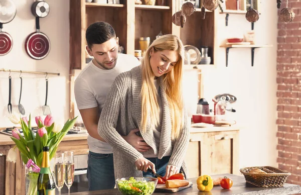 Romantik genç çift kucaklaşıyor ve birlikte yemek pişiriyor. — Stok fotoğraf