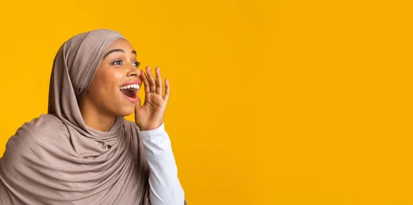 Emocionada mujer afromusulmana haciendo anuncio, gritando en el espacio de copia — Foto de Stock