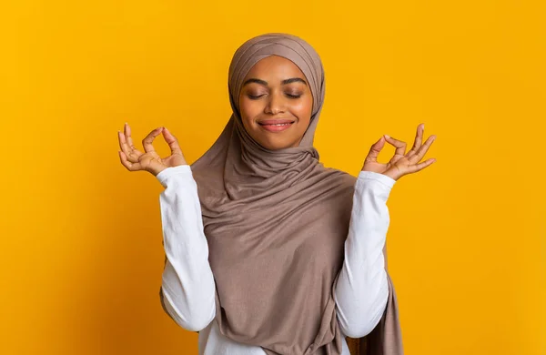 Potěšená černošky dívka v šátku dělat Mudra gesto se zavřenýma očima — Stock fotografie