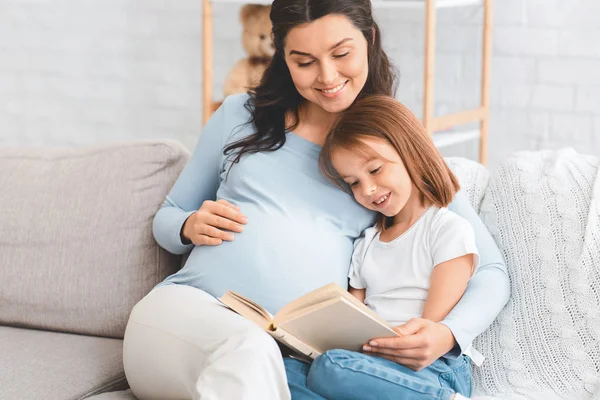 Blisko spodziewając kobieta czyta do małej córki — Zdjęcie stockowe