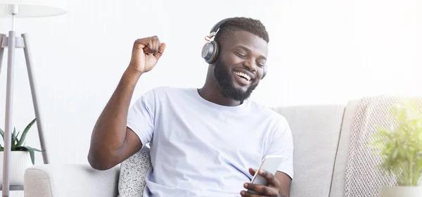 Positive black man listening to favorite music online — 스톡 사진