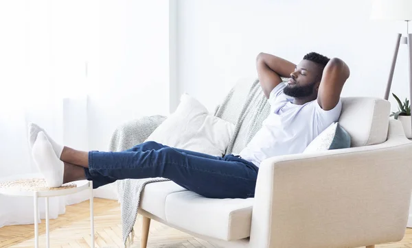 Ung afrikansk amerikansk man slappna av hemma, fritt utrymme — Stockfoto