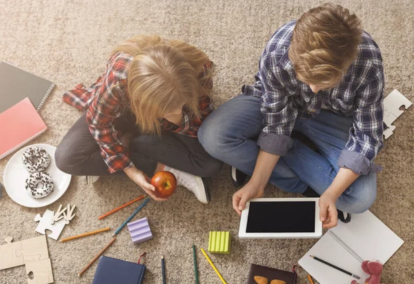 Brother and Sister Using Digital Tablet Sitting On Floor, Above-View — стоковое фото