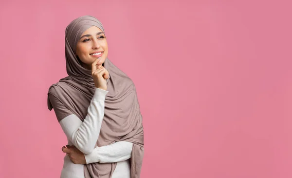 Bella ragazza musulmana pensando troppo a qualcosa, guardando oltre sfondo rosa — Foto Stock