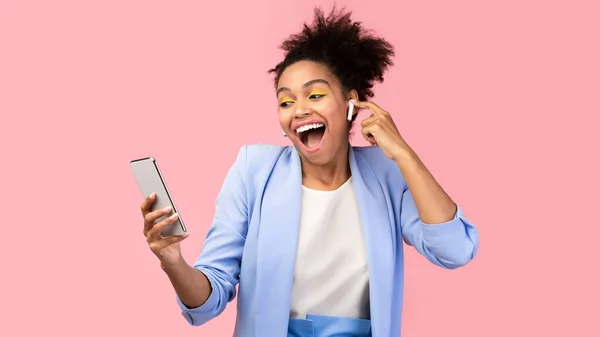 Portret van een lachende Afrikaanse vrouw die geniet van haar muziek — Stockfoto