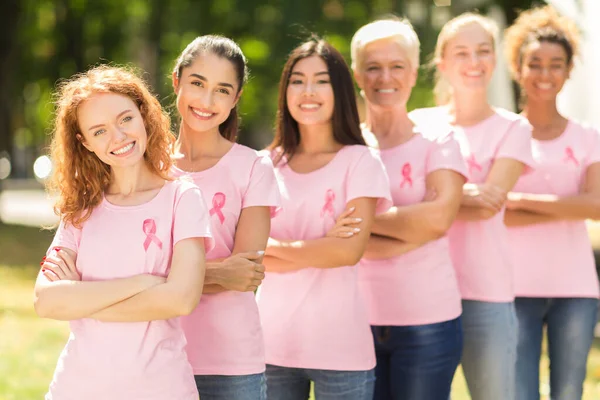 Senhoras multirraciais em camisetas cor-de-rosa em pé no parque, profundidade rasa — Fotografia de Stock